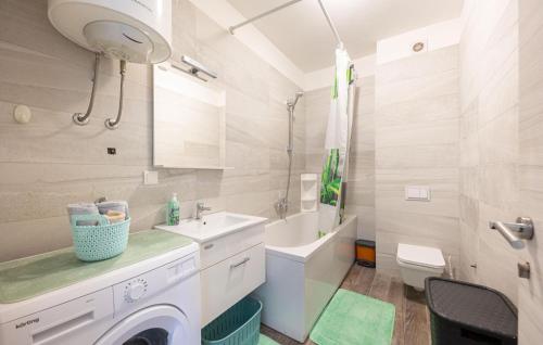 ein weißes Bad mit einer Waschmaschine in der Unterkunft Nice Home In Podstrana With House Sea View in Podstrana