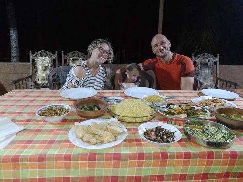 Ein Mann und eine Frau sitzen an einem Tisch mit Essen in der Unterkunft Gimanhala Cottage & Cookary Class in Anuradhapura