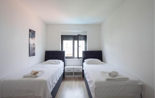 2 Betten in einem Zimmer mit weißen Wänden in der Unterkunft Beautiful Apartment In Kastel Kambelovac With Jacuzzi in Kaštela