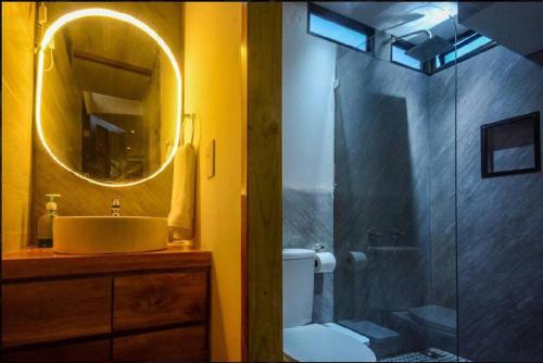 a bathroom with a shower and a sink and a mirror at Cabin VNV in Nosara