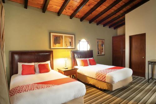 two beds in a hotel room with at Hacienda Corteza in Rosarito