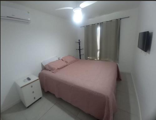 瓜拉久巴的住宿－Village Condomínio Porto Smeralda - Guarajuba，卧室配有粉红色的床和窗户。