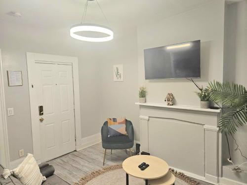 a living room with a chair and a flat screen tv at Fortune Suits and Apartment in Albany