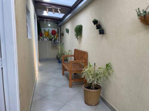 a hallway with a bench and potted plants at Hostel Quartos com banheiro individual perto do Aeroporto in Guarulhos