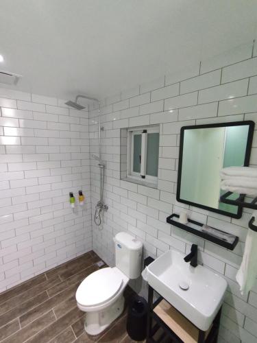 a white bathroom with a toilet and a sink at Liuqiu Guihua Homestay in Xiaoliuqiu