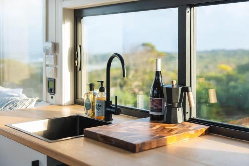 Currie的住宿－Tiny Rupetta，带水槽、瓶装葡萄酒的厨房台和窗户