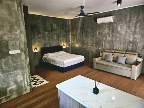 ein Schlafzimmer mit einem Bett, einem Sofa und einem Tisch in der Unterkunft Rugading Riverside Villa near Kota Kinabalu. in Kampong Rugarding