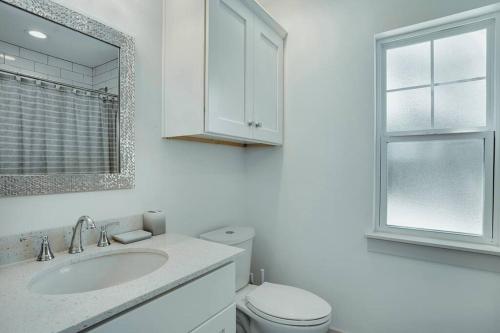 a white bathroom with a toilet and a sink at Lake Hm Hill Mountain View-BOAT Rental Available! in Canyon Lake