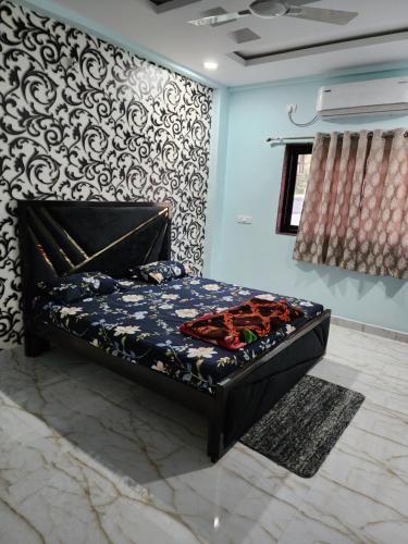 a bed in a room with a wall at Manidweepa farm house in Venkatāpur
