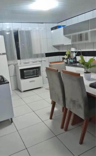 a kitchen with white cabinets and a table and chairs at Ap mobiliado in Guarapuava