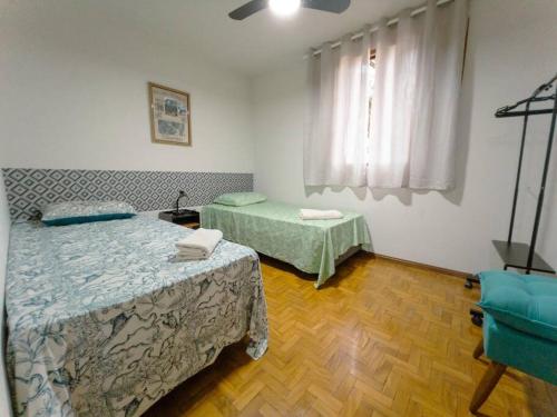 a bedroom with two beds and a window at Apartamento Smart Centro MC53 in Maringá