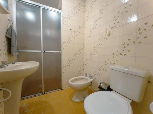 a bathroom with a toilet and a shower and a sink at Apartamento Smart Centro MC53 in Maringá