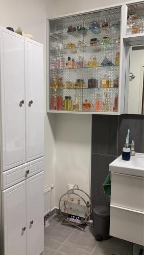 uma cozinha com armários brancos e um lavatório em Mi appartement mi maison em Guyancourt