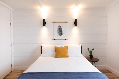 a bedroom with white walls and a bed with yellow pillows at Bonnie View Inn in Haliburton
