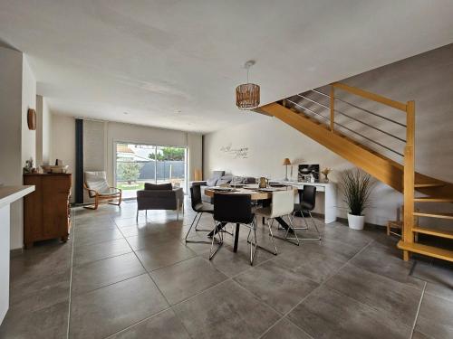 - un salon avec un escalier, une table et des chaises dans l'établissement Maison récente 3 étoiles, proche plage et forêt, 3 chambres, WiFi, jardin, secteur calme, La Faute-sur-Mer. - FR-1-476-188, à La Faute-sur-Mer