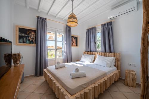 une chambre avec un grand lit dans une pièce dans l'établissement Villa Sea Walk Mykonos 200m to ftelia beach, à Mykonos