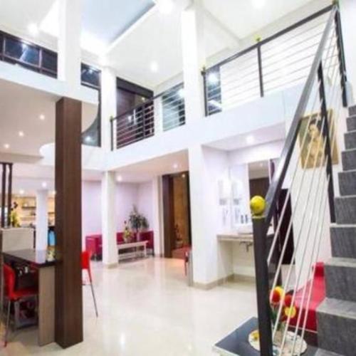 a living room with a staircase in a house at Mataram hotel in Tjakranegara