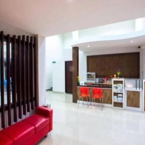 Il comprend un salon avec un canapé rouge et une cuisine. dans l'établissement Mataram hotel, à Tjakranegara
