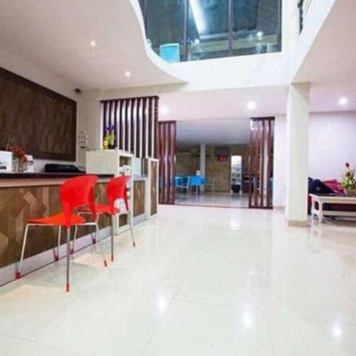 Il comprend un salon avec des chaises rouges et une cuisine. dans l'établissement Mataram hotel, à Tjakranegara