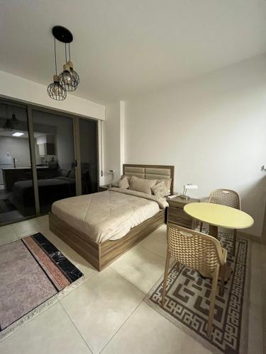 a bedroom with a bed and a table and chair at Aqaba Alraha village in Aqaba