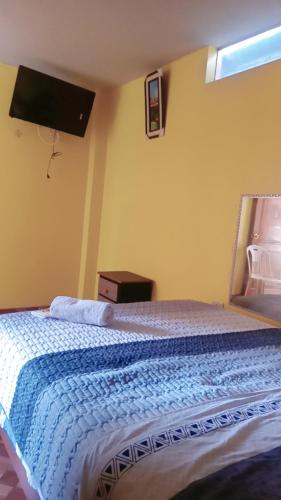 a bedroom with a bed with a blue blanket at Hospedaje PARAÍSO in Ayacucho