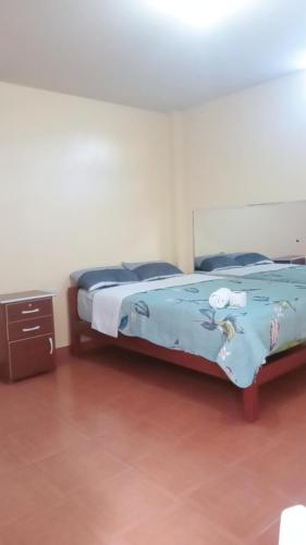 a bedroom with a bed with a blue comforter at Hospedaje PARAÍSO in Ayacucho