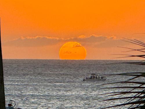 a boat in the ocean with a sunset at Ocean Luxe in Paradise - Le Paradis Royal in Rincon