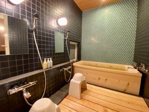 ein Badezimmer mit einer Badewanne, einem WC und einem Waschbecken in der Unterkunft Element in Nakafurano
