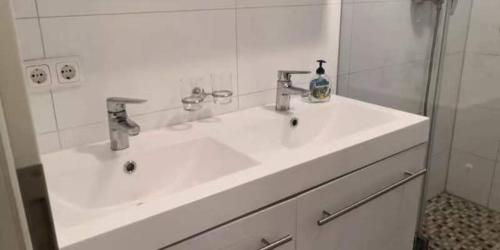 Biebrich的住宿－Traumhafte Ferienwohnung mit drei Schlafzimmer，白色的浴室设有水槽和镜子