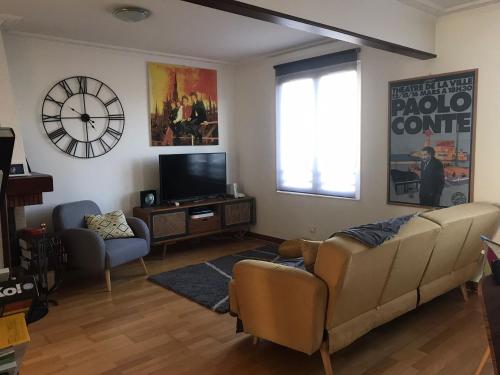 ein Wohnzimmer mit einem Sofa und einem TV in der Unterkunft Chambourcy poissy in Poissy