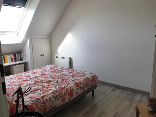 une chambre avec un lit avec une couette fleurie dans l'établissement Chambourcy poissy, à Poissy