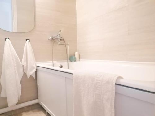 a white bathroom with a tub and a sink at SweetHome in Nha Trang