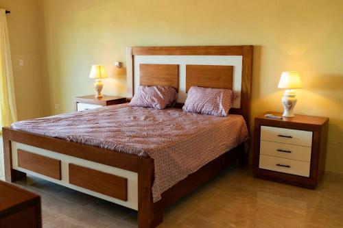 1 dormitorio con 1 cama grande y 2 mesitas de noche en Villa luxury puerto plata RD en San Felipe de Puerto Plata