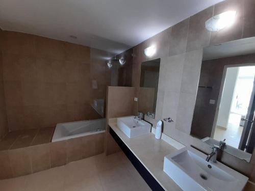 a bathroom with two sinks and a tub and a mirror at Villas de Playa Blanca, Rooftop Vista al Mar in Río Hato