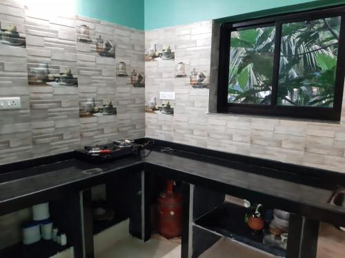 a bathroom with a black counter and a window at Dias Guest House in Canacona