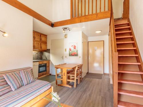 ein Wohnzimmer mit einer Treppe und eine Küche mit einem Tisch in der Unterkunft Appartement Plagne Soleil, 3 pièces, 6 personnes - FR-1-351-3 in Plagne Villages