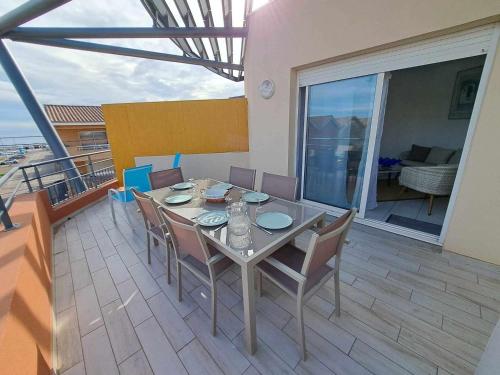 une salle à manger avec une table et des chaises sur un balcon dans l'établissement Appartement 3 pièces climatisé avec terrasse à Marseillan, parking privé, proche des commodités - FR-1-326-806, à Marseillan