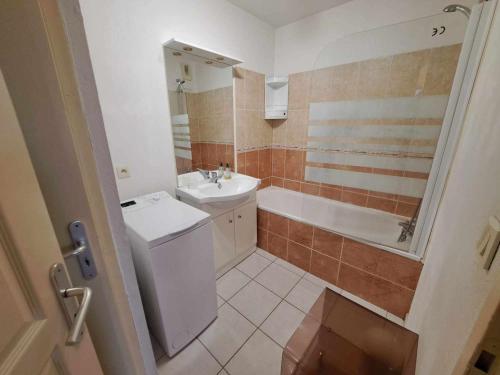 une salle de bain avec un lavabo, des toilettes et une baignoire dans l'établissement Appartement 3 pièces climatisé avec terrasse à Marseillan, parking privé, proche des commodités - FR-1-326-806, à Marseillan