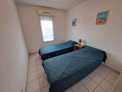 2 camas en una habitación pequeña con ventana en Appartement Marseillan, 3 pièces, 4 personnes - FR-1-326-806, en Marseillan