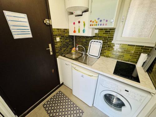 une cuisine avec une machine à laver et un évier dans l'établissement Bel appartement refait à neuf, au calme avec parking privatif à Agde - FR-1-723-131, au Cap d'Agde