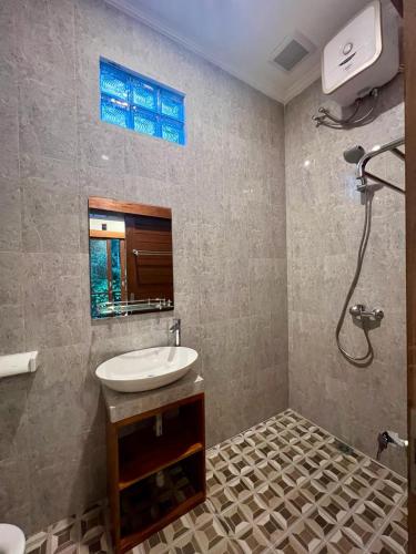 een badkamer met een wastafel en een douche bij Rare House in Ubud