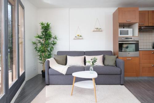 un salon avec un canapé et une table dans l'établissement Le Cosy : Terrasse • Parking • Piscine • Clim, à Grasse