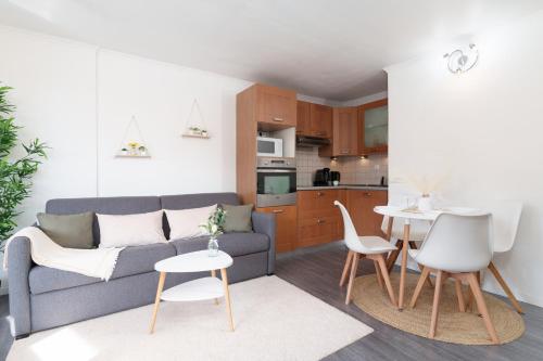 un salon avec un canapé et une table dans l'établissement Le Cosy : Terrasse • Parking • Piscine • Clim, à Grasse