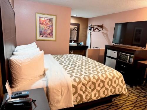 pokój hotelowy z łóżkiem i telewizorem z płaskim ekranem w obiekcie Annie Oakley Motel Oakley w mieście Oakley