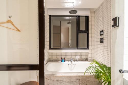 y baño con bañera blanca y lavamanos. en Mandala Residences, en Canggu