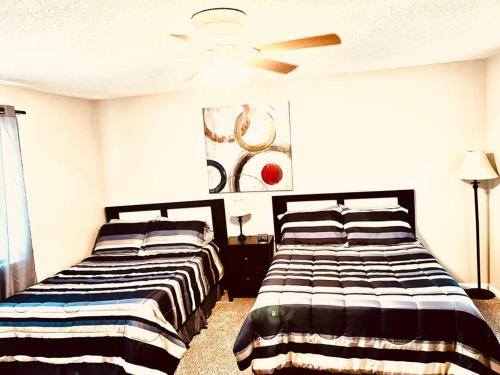 1 dormitorio con 2 camas y ventilador de techo en Mandarin Cheerful 2 Bedroom Townhouse w/fireplace, en Jacksonville