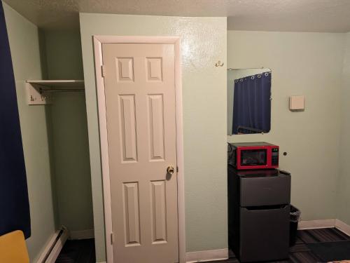 a door leading into a room with a red microwave at Tour Inn Motel in Howard City