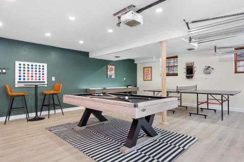 a ping pong table in a room with two tables and chairs at Game Room+Hot Tub+Pool+King Beds+More in Gansevoort