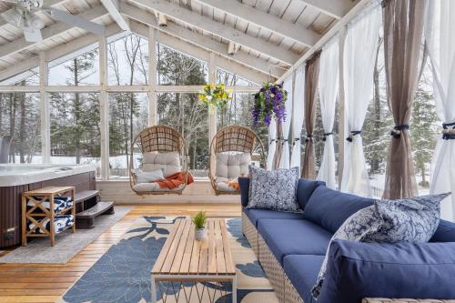 a living room with a blue couch and windows at Game Room+Hot Tub+Pool+King Beds+More in Gansevoort