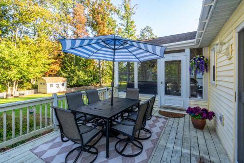 a black table with chairs and an umbrella on a deck at Game Room+Hot Tub+Pool+King Beds+More in Gansevoort